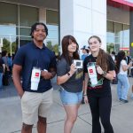 three students show promotional items